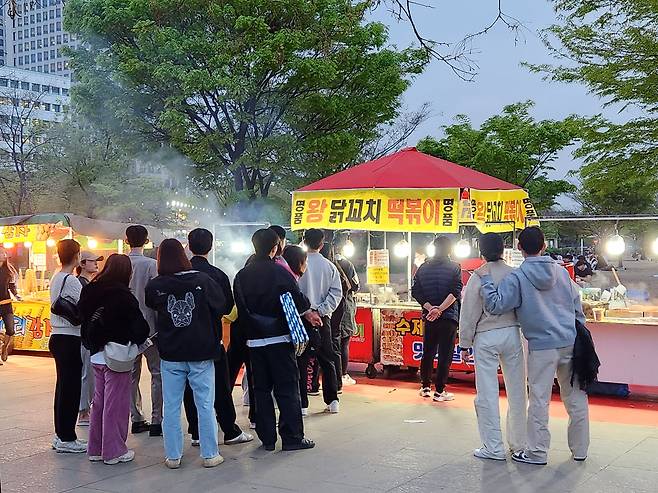 지난 17일 오후 7시쯤 서울 영등포구 여의도한강공원에서 길거리 음식을 파는 한 노점에 사람들이 줄을 서고 있다. /김태호 기자