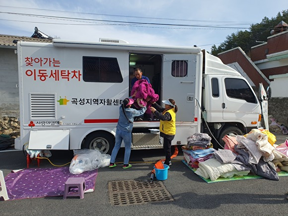 곡성지역자활센터 직원들이 찾아가는 이동세탁차에서 빨래를 하고 있다. [사진=곡성군]