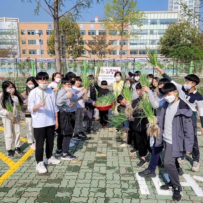 [울산=뉴시스] 울산 울주군 영화초등학교 학생들이 학교 텃밭에서 직접 재배한 '대파'를 들고 기념촬영 하고 있다. (울산시교육청 제공) *재판매 및 DB 금지