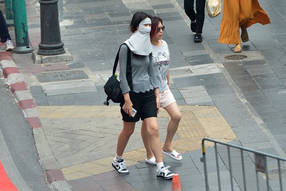 19일 태국 방콕에서 시민이 햇볕을 피하기 위해 얼굴 전체를 마스크로 가린 채로 길을 걷고 있다. 신화통신=연합뉴스