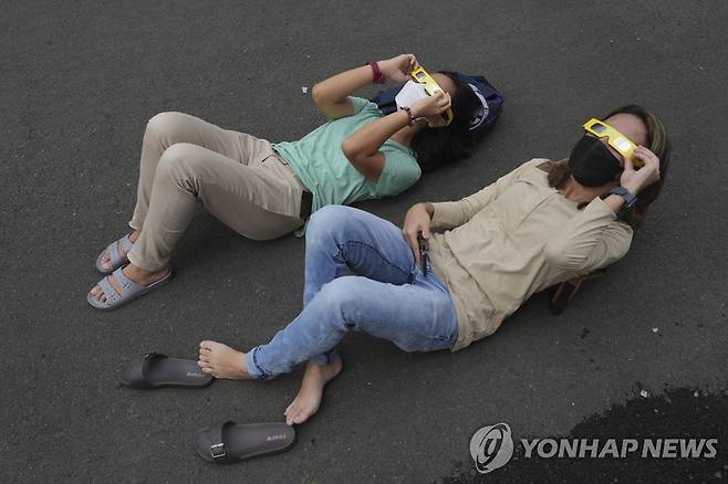 일식 관찰하는 사람들 (자카르타 AP=연합뉴스) 20일(현지시간) 인도네시아 자카르타에서 시민들이 부분 일식을 관찰하기 위해 보호안경을 쓰고 바닥에 누워 있다. 2023.4.20. photo@yna.co.kr