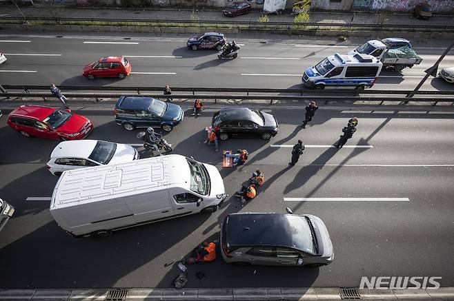 [베를린=AP/뉴시스]독일 베를린의 A100 고속도로가 24일 강력 접착제로 도로에 몸을 붙여 교통 흐름을 차단하려는 기후단체 '래스트 제너레이션' 회원들의 시위로 봉쇄돼 있다. 기후 운동가들은 이날 아침 수도 베를린에서 강력 접착제로 자신들의 몸을 도로에 붙임으로써 수도 전체의 교통을 마비시키려 했다. 2023.04.24.