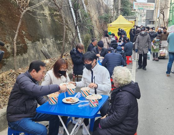 지난 2월 2일 오후 대구 북구 대현동 경북대학교 서문 인근 골목가에서 돼지고기 수육과 소고기국밥을 받은 사람들이 식사를 하고 있다. 이날 돼지고기 잔치는 이슬람 사원 건립을 반대하는 대현동 주민 중 일부가 주최했다. 김정석 기자