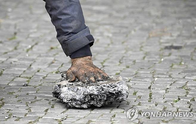 도로 접착 기후활동가 연행 위해 아스팔트 뜯어낸 경찰 / 사진=AFP 연합뉴스