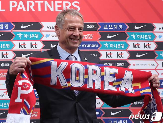 위르겐 클린스만 신임 한국 남자 축구국가대표팀 감독이 9일 경기 파주 축가대표팀 트레이닝센터(NFC)에서 취임 기자회견에서 머플러를 들고 기념촬영을 하고 있다. 2023.3.9/뉴스1 ⓒ News1 송원영 기자