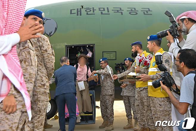 무력충돌이 벌어진 수단에서 체류 중이던 우리 교민 등이 24일(현지시간) 공군의 C-130J '슈퍼허큘리스' 수송기를 타고 사우디아라비아 제다 공항에 도착, 사우디 군 관계자들의 환영을 받고 있다. (국방부 제공) 2023.4.25/뉴스1