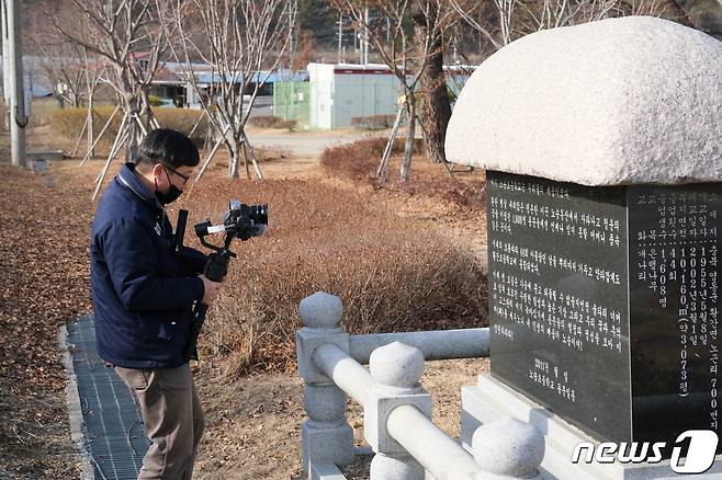 영동군청 홍보팀 직원이 마을 유래비를 촬영하고 있다. (영동군 제공)