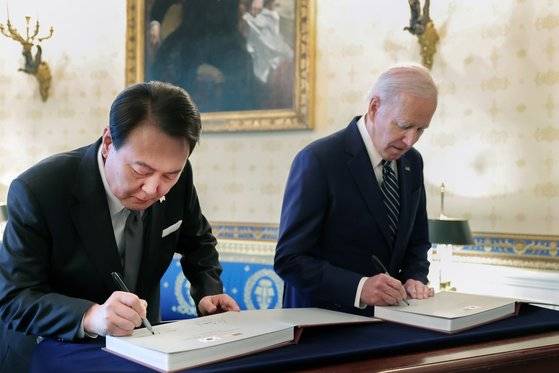 미국을 국빈 방문한 윤석열 대통령과 조 바이든 미국 대통령이 25일(현지시간) 워싱턴DC 백악관 관저에서 열린 친교행사에서 한미 동맹 70주년 사진집에 서명하는 모습. 강정현 기자