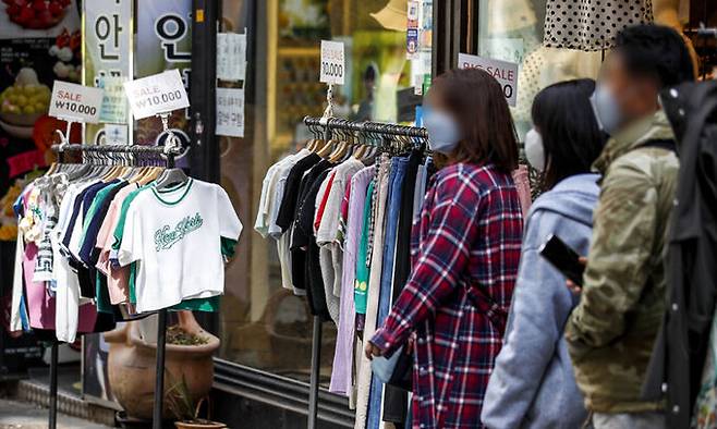 지난 23일 서울 중구 명동의 한 의류매장을 찾은 시민들이 제품을 살펴보고 있다. 뉴시스