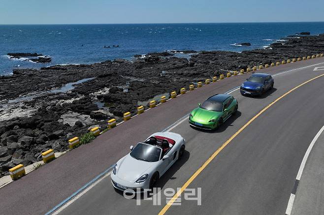 포르쉐의 ‘718 박스터 GTS 4.0’(왼쪽), ‘타이칸 크로스 투리모스 4S’(가운데), ‘마칸 GTS’(오른쪽) 차량이 제주도 해안도로를 주행하고 있다.  (사진=포스쉐코리아)