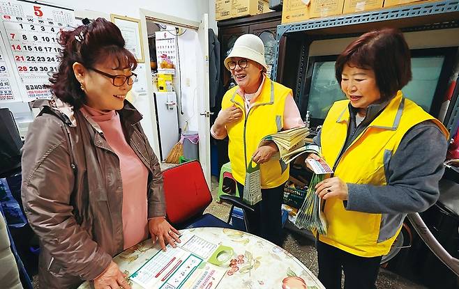 차복자 월곡1동 구석구석발굴단장(가운데)이 지난 12일 오후 동네의 한 이삿짐센터에서 위기가구 발굴 안내문을 건넨 뒤 활동에 관해 설명하고 있다.