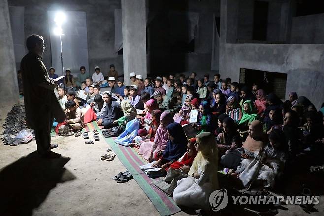 노천에서 수업하는 아프간 야학교사 (칸다하르 EPA=연합뉴스) 20일(현지시간) 아프가니스탄 칸다하르주의 시르 수르흐 바바 마을의 노천 야학에서 한 교사가 학생들을 상대로 수업을 진행하고 있다. 야학은 학교가 부족한 이곳 어린이들의 문맹을 퇴치하기 위해 마련된 것으로, 폭염과 먼지, 바람에 시달려야 하는 열악한 수업환경에서 운영되고 있다. 2022.08.22 jsmoon@yna.co.kr