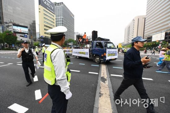 노동절을 맞아 전국 곳곳에서 대규모 집회가 열린 1일 서울 종로구 광화문 네거리에서 경찰들이 교통정리를 하고 있다. 서울지방경찰청은 서울광장에서 열리는 세계 노동절 대회의 행진시간인 오후 3시 반부터 6시까지 세종대로와 종로 4가까지 진행방향 전차선 도로에서 차량통행이 일제히 제한된다고 밝혔다. /문호남 기자 munonam@