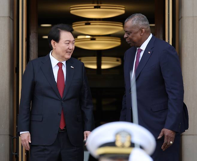 South Korean President Yoon Suk Yeol (left) and US Secretary of Defense Lloyd J. Austin III have a conversation after the honor guard welcome ceremony at the US Department of Defense in Washington, DC on Thursday. (Yonhap)