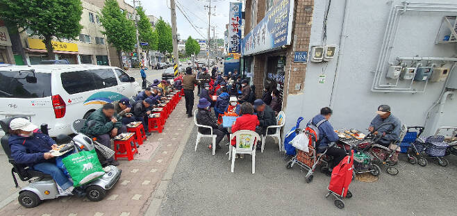 26일 인천 서구 석남동 무료급식소인 '나눔의 울타리' 앞에서 주민들이 점심식사를 하는 모습. 광명의집 제공