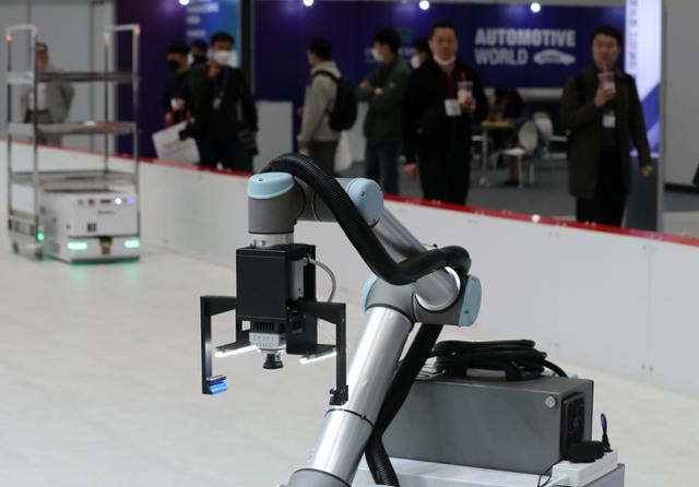 서울 강남구 코엑스에서 12일 열린 2023 한국전자제조산업전 & 오토모티브월드코리아를 찾은 관람객들이 산업용 로봇을 둘러보고 있다. 뉴스1