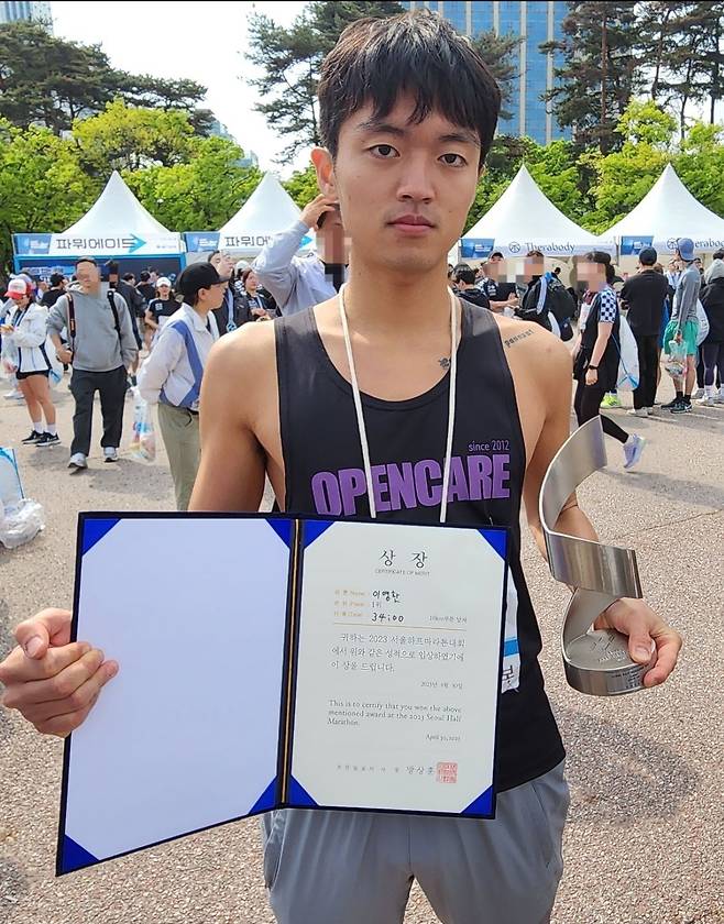 2023 서울하프마라톤 10km 부문 남자 1위 이영환씨가 30일 여의도공원에서 상장 및 트로피와 함께 기뻐하고 있다. 체육교육 전공인 그는 이번 대회에서 본인 최고 기록을 50초가량 줄이는 기쁨을 맛봤다. /박강현 기자