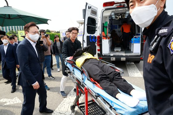 간호법 저지를 위해 국회 앞에서 단식 농성을 6일째 이어오던 곽지연 대한간호조무사협회장이 30일 오후 조규홍 보건복지부 장관(왼쪽)과 현장 의사의 설득 끝에 병원으로 이송되고 있다. 뉴스1