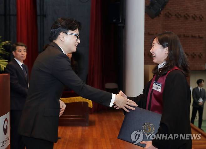 신임 검사 임용장 수여하는 한동훈 장관 (서울=연합뉴스) 한동훈 법무부 장관이 1일 정부과천청사에서 열린 '신임 검사 임관식'에서 신임 검사에게 임용장을 수여 후 악수하고 있다. 2023.5.1 [법무부 제공. 재판매 및 DB 금지] photo@yna.co.kr