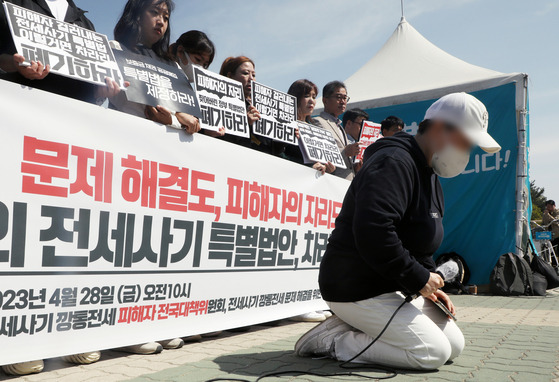 28일 오전 국회 앞에서 열린 ‘정부여당의 전세사기 특별법안 철회 촉구 기자회견’에서 전세사기·깡통전세 피해자 전국대책위원회 회원이 무릎을 꿇고 피해 구제를 호소하고 있다. [뉴스1]