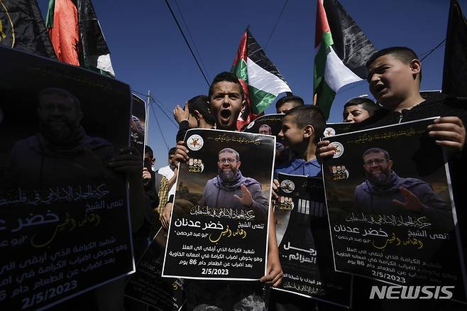 [AP/뉴시스] 팔레스타인 지하드 요원인 카데르 아드난이 이스라엘 감옥서 단식으로 2일 사망하자 서안지구 팔 인 아동들이 팔 국기와 아드난 포스터를 흔들고 있다