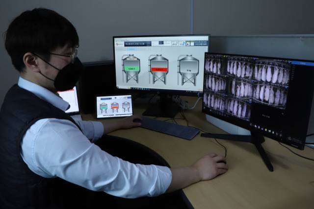 CJ피드앤케어 관리자가 축산농가 관제실에서 ICT 통합 모니터링을 살펴보고 있다. /사진 제공=CJ제일제당