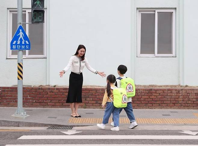 삼성전자, 크라운제과와 손잡고 '안전한 하굣길 프로젝트' (서울=연합뉴스) 삼성전자 모델이 삼성전자와 크라운제과가 '아이 LIKE 제트 봇 AI' 캠페인 일환으로 제작한 '스쿨존 가방 안전 커버' 굿즈를 선보이고 있다. 2023.5.2. [삼성전자 제공. 재판매 및 DB 금지]