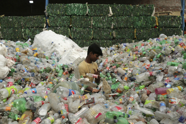 한 인도 노동자가 인도 잠무 외곽의 산업 지역에서 재활용될 플라스틱 병을 선별하고 있다. AP=뉴시스