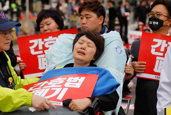 3일 서울 여의도 국회 앞에서 ‘간호법·면허 박탈법 강행 처리 더불어민주당 퇴출을 위한 400만 보건복지의료연대 규탄대회’가 진행되는 가운데 간호법 저지를 위해 9일째 단식 농성 중인 곽지연 대한간호조무사협회장이 환자 이송용 침대에 누워 울먹이고 있다./뉴시스