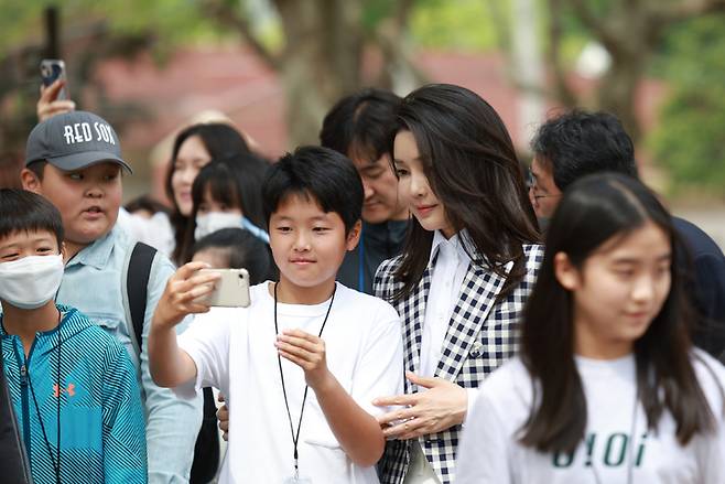 [서울=뉴시스] 윤석열 대통령 부인 김건희 여사가 4일 서울 용산 대통령실 앞 미군기지 반환부지에 조성된 용산어린이정원에서 어린이들과 기념촬영하고 있다. (사진=대통령실 제공) 2023.05.04. photo@newsis.com *재판매 및 DB 금지
