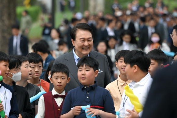 윤석열 대통령이 4일 서울 용산 대통령실의 앞마당에 조성된 용산 어린이정원 개방행사에서 어린이들과 함께 웃고 있다. 연합뉴스