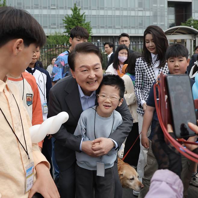 윤석열 대통령 부부가 4일 서울 용산 대통령실 앞 미군 기지 반환 부지에 조성된 용산어린이정원에서 어린이들과 함께 기념 촬영하고 있다. /대통령실 제공