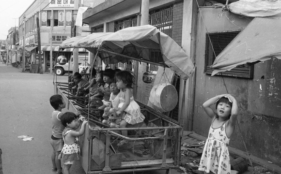 추억의 말타기 리어카 - 1979년 서울의 한 동네에서 어린이들이 이동식 말타기를 타고 있다. 놀이터도 흔치 않아  놀이기구가 많지 않았던 이 시절 가끔씩 동네를 찾는 말타기 리어카는 어린이들에게 최고 인기놀이기구였다. 어린이들이 돈을 지불하고 일정 시간동안 스프링달린 말을 타며 즐거워했다. 1979. 7. 14 서울신문 사진창고