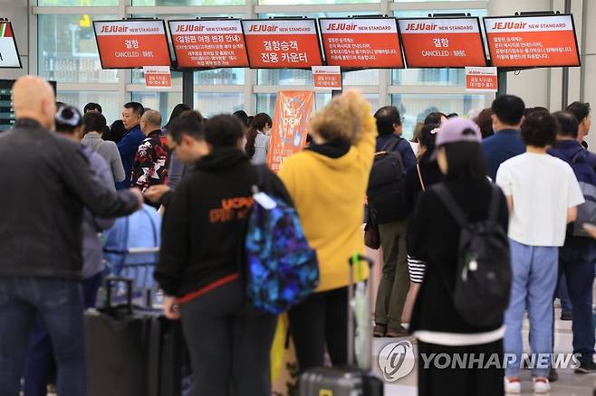 기약 없는 기다림 (제주=연합뉴스) 박지호 기자 = 5일 오전 제주국제공항 출발층 항공사 카운터가 결항편 대체 항공권을 구하려는 여행객들로 붐비고 있다. 2023.5.5 jihopark@yna.co.kr