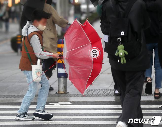 부산에 호우·강풍특보가 내려진 5일 부산 해운대해수욕장 인근에서 한 어린이가 몰아치는 비바람에 우산을 부여잡고 힘겹게 걷고 있다. 2023.5.5/뉴스1 ⓒ News1 윤일지 기자