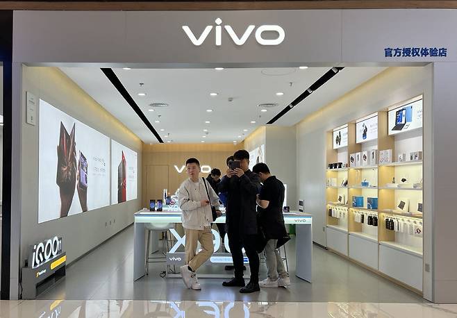 중국 산시성 시안의 쇼핑몰 안 비보(vivo) 매장에서 소비자가 폴더블폰 제품을 체험해 보고 있다. /시안=김남희 특파원