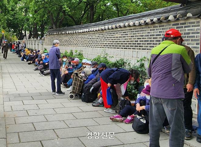 7일 오전 서울 종로구 탑골공원 인근에 노인들이 무료급식을 받기 위해 줄 지어 기다리고 있다. 빨간 모자를 쓴 하늘궁 무료급식소 관계자가 대기줄을 통제하고 있다. 김세훈 기자