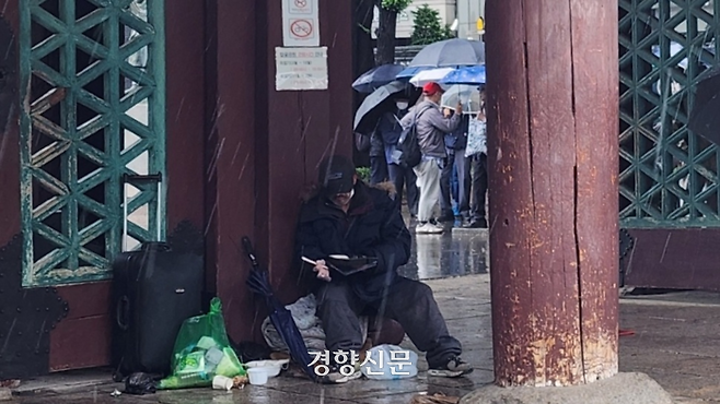 비가 내리던 지난 6일 서울 종로구 탑골공원에서 한 시민이 ‘하늘궁 무료급식소’에서 받은 도시락을 먹고 있다. 김세훈 기자