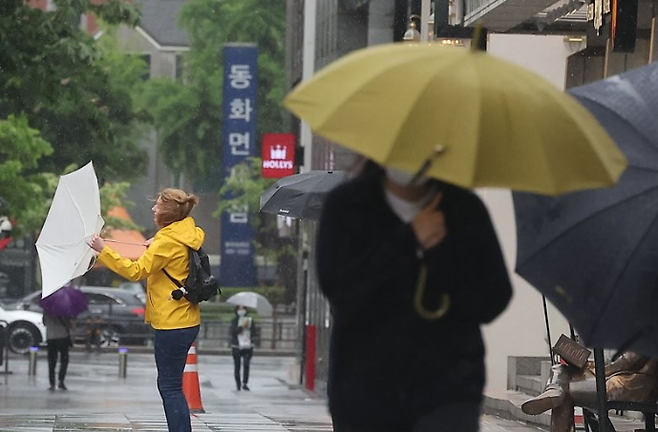 6일 서울 광화문 광장에서 한 외국인 여성이 쓴 우산이 강풍에 뒤집혔다. / 사진=연합뉴스