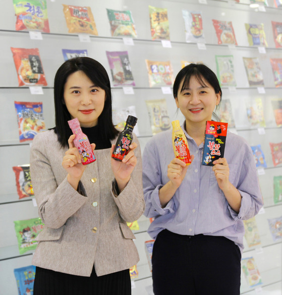 Models promote Samyang Food's sauces including the original Buldak Sauce on Monday. [SAMYANG FOODS]