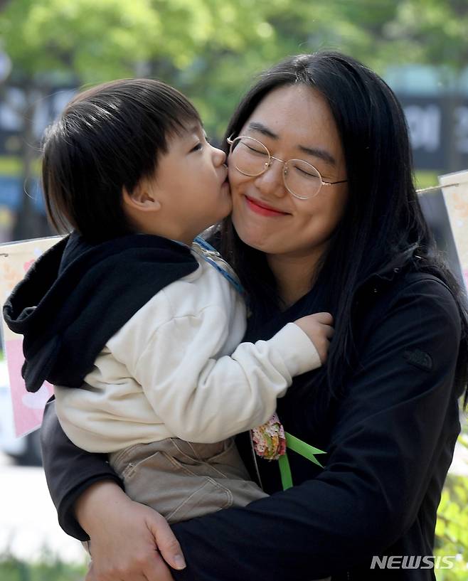 [광주=뉴시스] 변재훈 기자 = 광주 북구청 직장어린이집 한 원아가 어버이날인 8일 광주 북구 용봉동 구청 광장 앞에서 직접 만든 카네이션을 전한 뒤 어머니 볼에 뽀뽀하고 있다. 2023.05.08. wisdom21@newsis.com