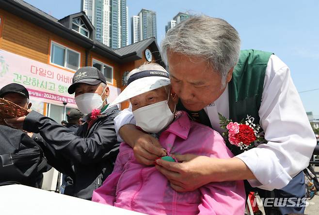 [서울=뉴시스] 권창회 기자 = 어버이날인 8일 오전 서울 동대문구 다일공동체 밥퍼나눔운동본부에서 관계자가 어버이날 행사 일환으로 무의탁 어르신에게 카네이션을 달아주고 있다. 2023.05.08. kch0523@newsis.com