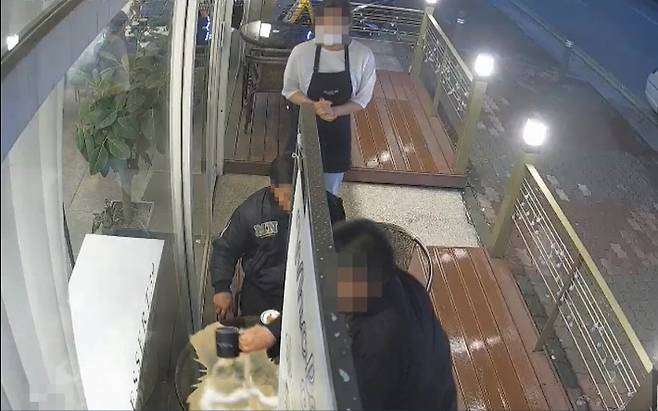 인터넷 커뮤니티에 올라온 CCTV 영상. 한 중년 남성이 일부러 카페 야외테라스 식탁 위에 커피를 쏟는 모습. 인터넷 커뮤니티 동영상 화면 캡처