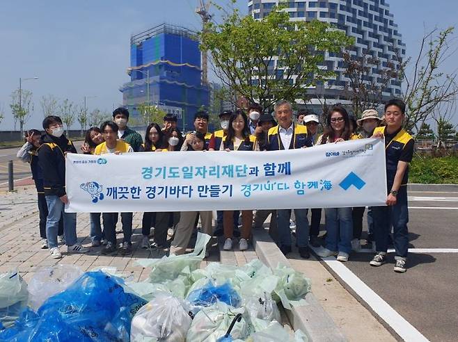 경기도일자리재단이 9일 시흥 거북섬에서 자발적인 자연환경보전활동을 한 뒤 기념사진을 찍고 있다.