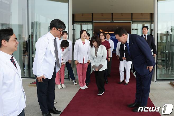 윤석열 대통령이 11일 서울 용산 대통령실 청사에서 열린 코로나19 중앙재난안전대책본부 회의를 마친 후 의료진을 배웅하고 있다. 윤 대통령은 이날 "3년 4개월 만에 국민께서 일상을 되찾으시게 돼서 기쁘게 생각한다"며 사실상 '코로나19 엔데믹'을 선언했다. (대통령실 제공) /뉴스1