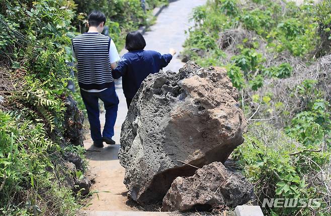 [제주=뉴시스] 우장호 기자 = 관광객들이 11일 오후 제주시 애월읍 한담해안 산책로에 떨어진 커다란 바위 옆으로 걸어가고 있다. 관광객들이 많이 찾는 대표 관광지인 한담해안산책로는 2016년과 2021년에도 낙석 사고가 발생해 출입 통제가 이뤄진 바 있다. 2023.05.11. woo1223@newsis.com