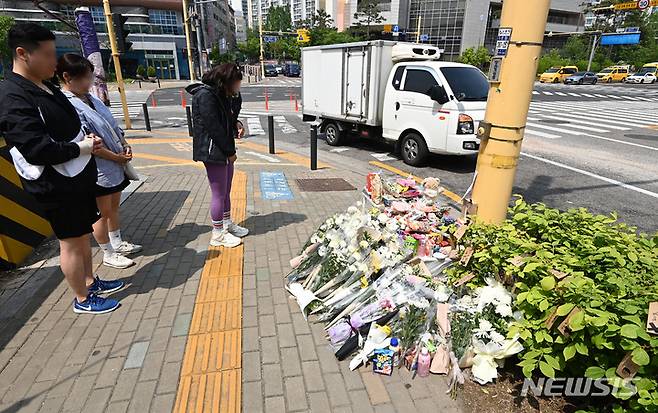 [수원=뉴시스] 김종택 기자 = 11일 경기도 수원시 권선구의 한 사거리에 전날 어리이보호구역(스쿨존)에서 시내버스에 치여 숨진 초등학생을 추모하는 추모 물품들이 놓여 있다. 2023.05.11. jtk@newsis.com