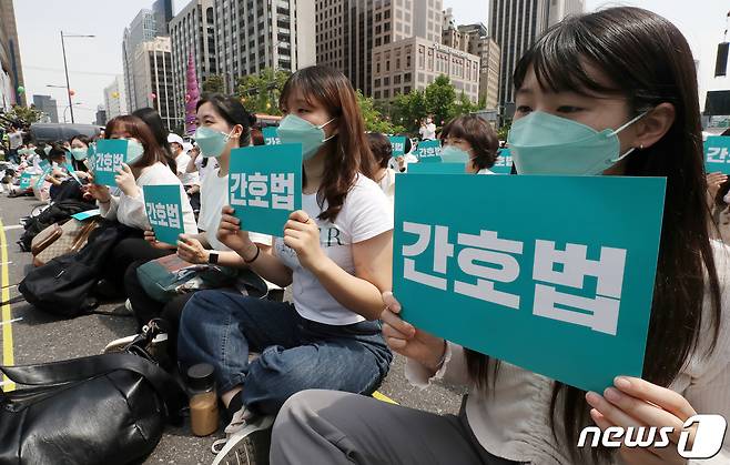 대한간호협회 간호사들이 12일 오후 서울 동화면세점 앞 세종대로에서 열린 국제간호사의 날 기념 집회에서 피켓을 들고 간호법 제정을 촉구하고 있다. 2023.5.12/뉴스1 ⓒ News1 박세연 기자