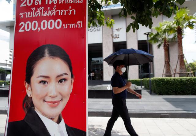 9일 태국 방콕에서 한 시민이 푸어타이당 패통탄 친나왓 후보의 선거 포스터를 지나고 있다. 방콕=EPA 연합뉴스