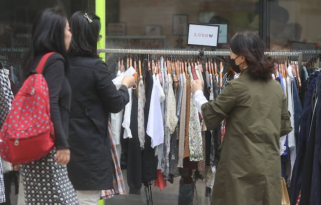 서울 중구 명동의 한 거리에 위치한 의류 매장에서 시민들이 옷을 구경하고 있다.[연합]